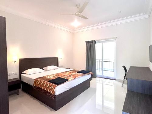 a bedroom with a bed and a large window at Morjim Sunset Guesthouse- Apartments with Kitchen & AC Rooms in Morjim