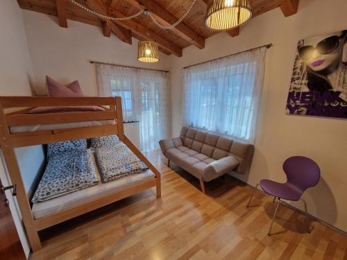 a bedroom with a bunk bed and a couch at DSW Ferienhaus in Oberperfuss