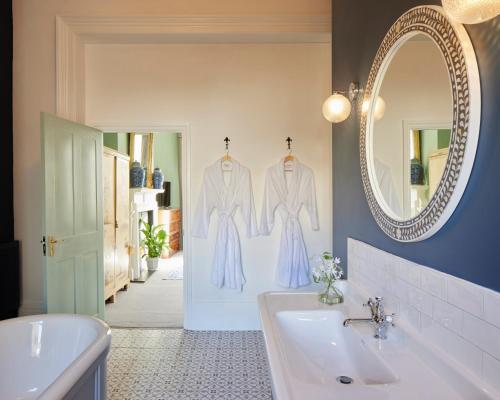 W łazience znajduje się umywalka i lustro. w obiekcie Lansdowne House Hove w Brighton and Hove