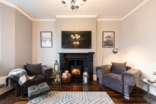 a living room with a fireplace and a tv at Awel y Mor in Llandudno