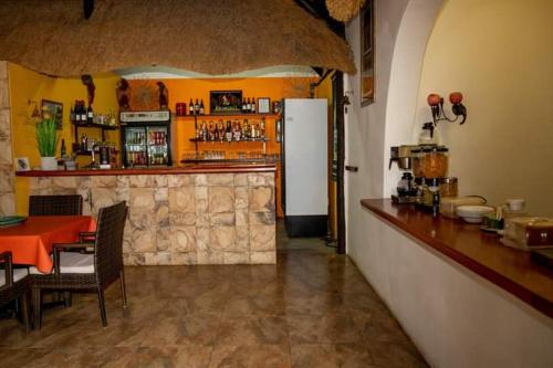 a bar in a restaurant with a table and a refrigerator at Lion's Den Guesthouse Otjiwarongo in Otjiwarongo