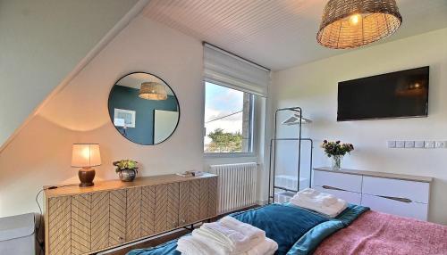 a bedroom with a bed and a mirror and a tv at Cadre privilégié et vue mer à Fréhel in Fréhel