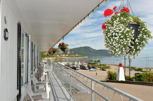 a balcony with flowers and a view of a parking lot at Auberge Sur Mer Charlevoix in Saint-Siméon