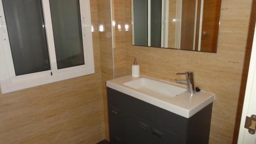 y baño con lavabo y espejo. en Apartamento zona playa de San Sebastian, en Sitges