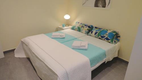 a bedroom with a bed with two towels on it at Apartamento zona playa de San Sebastian in Sitges