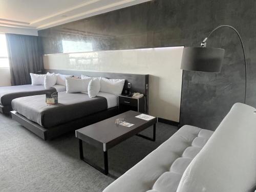 a hotel room with a couch and a table at Suites Inn la Muralla Hotel & Spa in Toluca