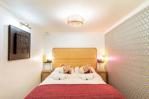 een slaapkamer met een groot bed en een rode deken bij Chic Apartment South Paris • 90 m² up to 8 persons • Villa des Ammonites in Meudon