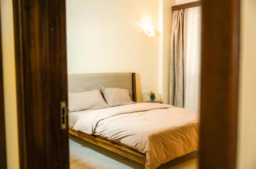 a bedroom with a bed and a mirror at Shared room in three bedrooms, private bathroom, gym, office area, kitchen, Wonderiss Home Westland Living in Nairobi