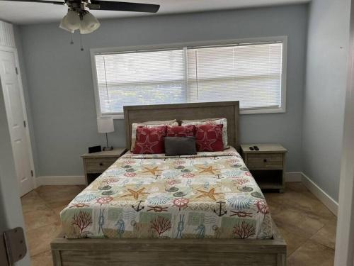 a bedroom with a bed with red pillows at Gulf Access Canal Home! in Cape Coral