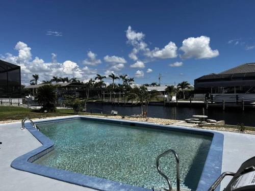a large swimming pool in a resort with a lake at Gulf Access Canal Home! in Cape Coral