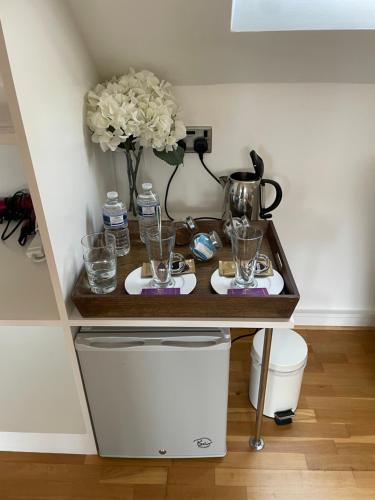 a table with glasses and a vase of flowers at The Corner House in Rochester