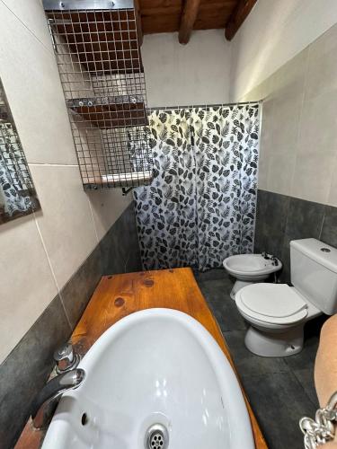 a bathroom with a white tub and a toilet at Cabañas del Amanecer in Tanti