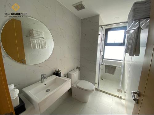 ein Badezimmer mit einem WC, einem Waschbecken und einem Spiegel in der Unterkunft CĂN HỘ TMS LUXURY RESIDENCES 28 NGUYỄN HUỆ QUY NHƠN in Quy Nhon
