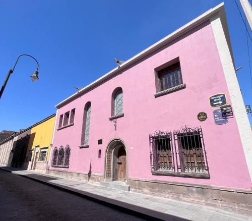 a pink building on the side of a street at Casa Maka in San Luis Potosí