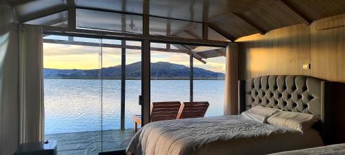 a bedroom with a bed and a view of the water at Titicaca Halso Los uros in Puno
