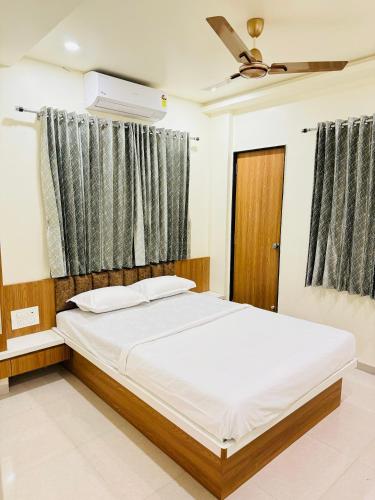 um quarto com uma cama grande e uma ventoinha de tecto em HOTEL EKANT em Daulatābād