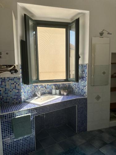 a bathroom with a sink and a window at Bengiorne! Casa Ginestra in Raiano