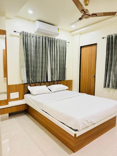 a bedroom with a large bed with a window at HOTEL EKANT in Daulatābād