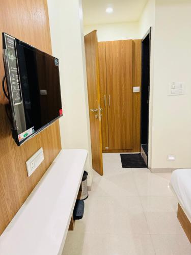 um quarto com uma televisão na parede e uma cama em HOTEL EKANT em Daulatābād