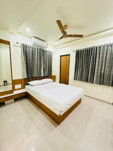 a bedroom with a bed and a ceiling fan at HOTEL EKANT in Daulatābād