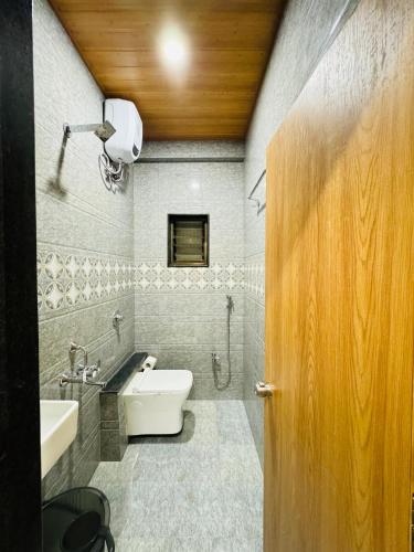 a bathroom with a white toilet and a sink at HOTEL EKANT in Daulatābād