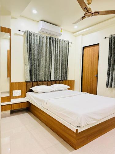 um quarto com uma cama e uma janela em HOTEL EKANT em Daulatābād