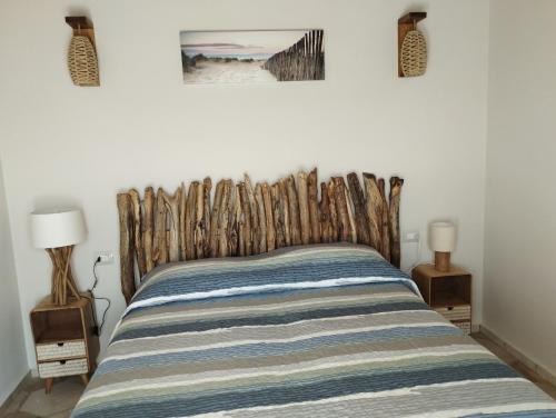 een slaapkamer met een bed met een houten hoofdeinde bij Col di Pietra in Giuncarico