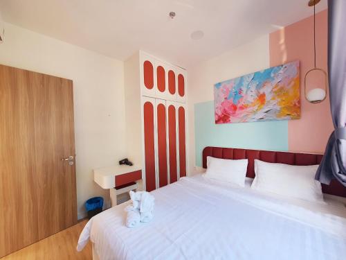 a bedroom with a white bed and a painting at Tony Apartment Soho Q1 in Ho Chi Minh City