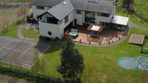 z góry widok na dom z kortem tenisowym w obiekcie Captiva Wexford - Your Ultimate Luxury Family Villa Getaway w mieście Kilmuckridge