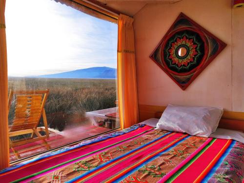 een slaapkamer met een bed en een raam met uitzicht bij Titicaca Halso Los uros in Puno