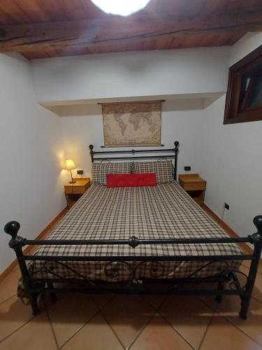 Un dormitorio con una cama con una almohada roja. en La Taverna Alloggio ad uso turistico - VDA -Sarre - CIR- 0073, en Aosta