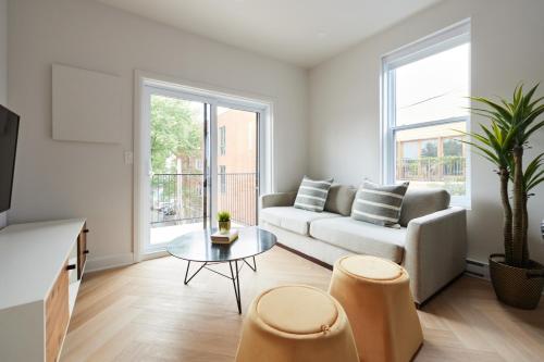 a living room with a couch and a table at New and Cozy 3 bedroom in Le Plateau by Denstays in Montréal