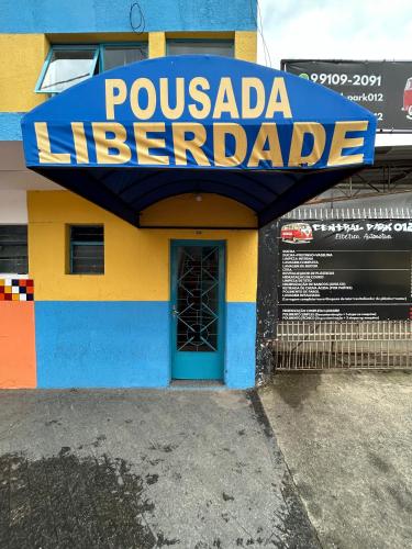a building with a sign that reads poulada interpreter at Hotel Pousada Liberdade in Pindamonhangaba