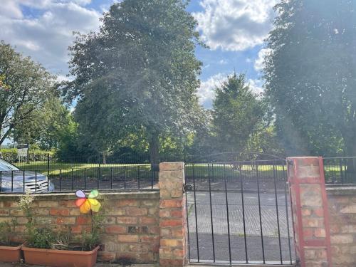 a wrought iron fence with a gate with a flower on it at Lovely 2 bedroom house overlooking park, Free parking in Belfast