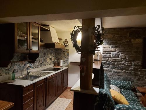 una cocina con fregadero y un sofá en una habitación en La Taverna Alloggio ad uso turistico - VDA -Sarre - CIR- 0073, en Aosta