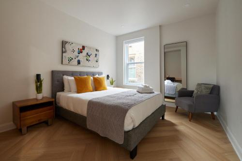a bedroom with a large bed and a chair at Urban Gem in Le Plateau by Denstays in Montréal