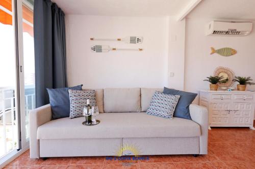 un sofá en la sala de estar con almohadas azules en Manhattan View with pool, en Benidorm