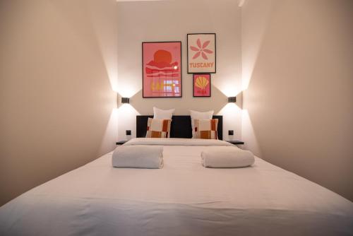 une chambre avec un grand lit blanc avec deux oreillers dans l'établissement Lovely Flat in the marais, à Paris