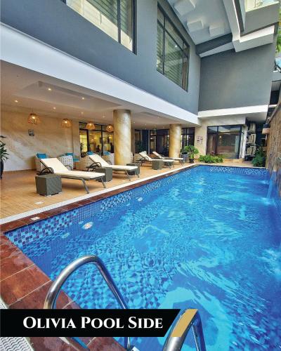 a swimming pool in a hotel with couches and chairs at Vintano Hotel in Lekki