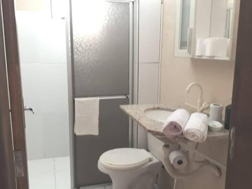 a bathroom with a toilet and a sink and a shower at Casa privada - Balneário Gaivota-SC 150 metros do mar in Sombrio