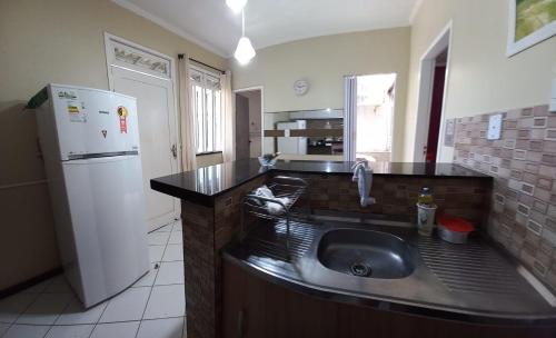 a kitchen with a sink and a refrigerator at Apartamento Mobiliado temporada in Aracaju