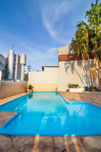 a blue swimming pool in front of a building at Hotel Los Angeles in Cuiabá