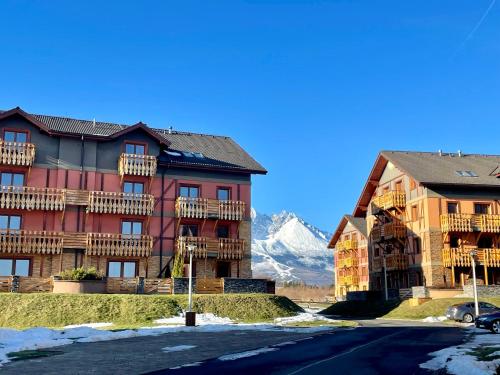 un gran edificio con una montaña en el fondo en Apartment KIMO - stunning view of High Tatras, en Veľká Lomnica