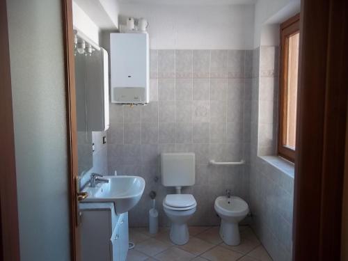 a bathroom with a white toilet and a sink at Trilocale BELVEDERE Alloggio ad uso turistico - VDA - LA THUILE - CIR 0068 in La Thuile