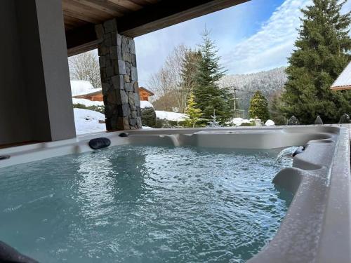 a jacuzzi tub in a house with snow at Chalet Louléa - Luxueux, au calme avec Spa in Xonrupt-Longemer