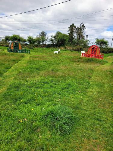 two tents in a field of green grass at Glamping Pod in St Austell Sleeps 2 with Spa Pool in Lanivet