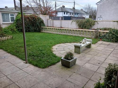 a yard with a statue of a dog sitting on a bench at Airbnb Guesthouse in Athlone