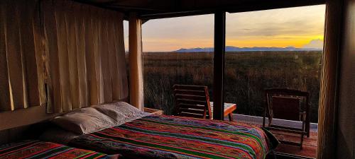 1 dormitorio con cama y ventana con vistas en Titicaca Vista amanecer, en Puno