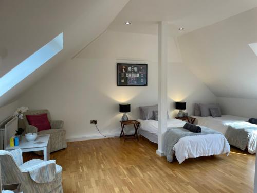 a attic room with two beds and a couch at The Corner House in Rochester