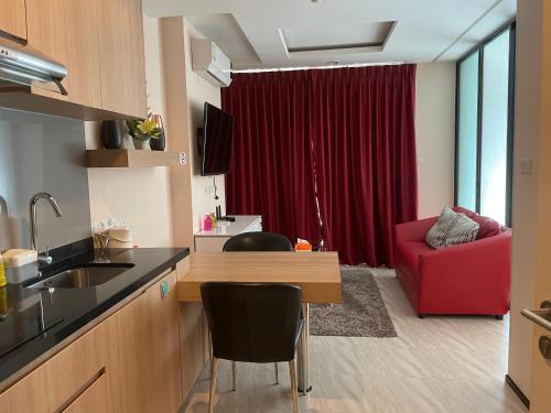 a kitchen and living room with a red couch at The Chezz by Apple & Frank in Pattaya Central